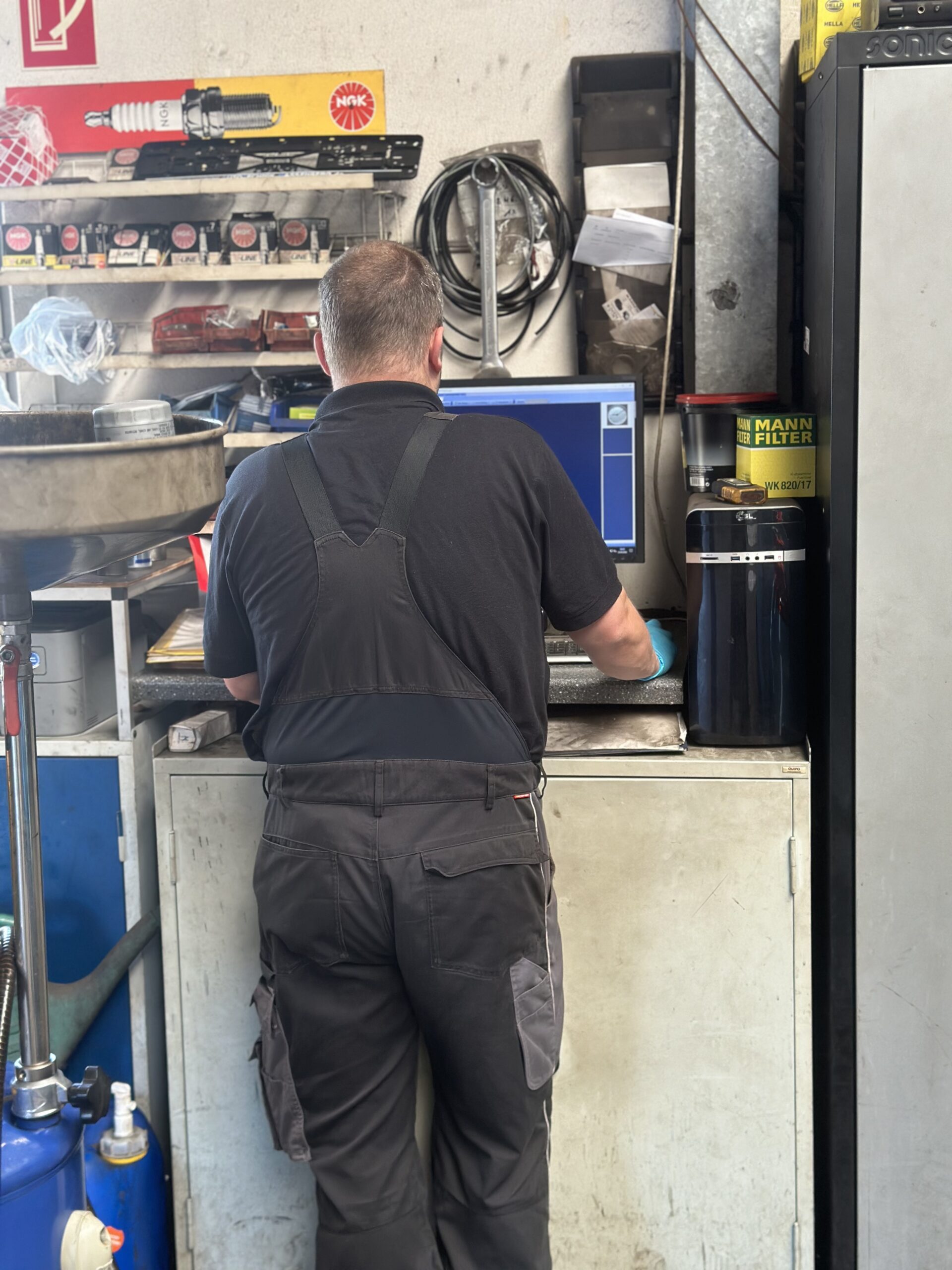 Kfz-Meachatroniker am PC in einer Autowerkstatt